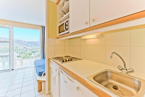 une cuisine avec un évier et une grande fenêtre dans l'établissement Résidence le Hameau de Cap Esterel - maeva Home - Appartement 2 pièces 4 personnes - Sélection MAE-6643, à Saint-Raphaël