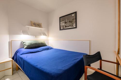 une chambre avec un lit avec une couette bleue dans l'établissement Résidence le Hameau de Cap Esterel - maeva Home - Appartement 2 pièces 4 personnes - Sélection MAE-6643, à Saint-Raphaël
