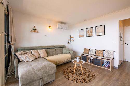 un salon avec un canapé et une table dans l'établissement Résidence le Village de Cap Esterel - maeva Home - Appartement climatisé vue mer 2 pièces 4 personnes - Prestige - super Home MAE-8991, à Saint-Raphaël