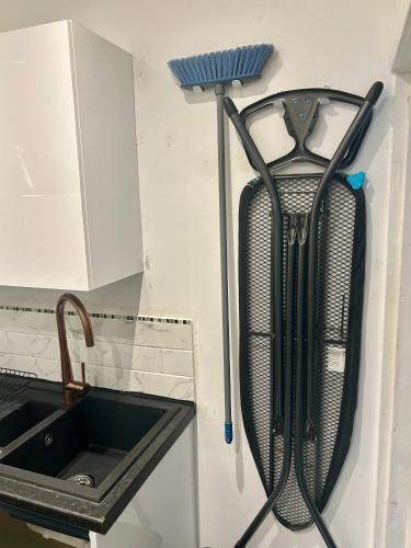 a kitchen with a sink and a hose hanging from the wall at Luxury studio apartment, Beckenham in Elmers End