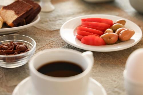 a cup of coffee and a plate of vegetables and bread at Panorama Rooms in Pirgos Dhirou