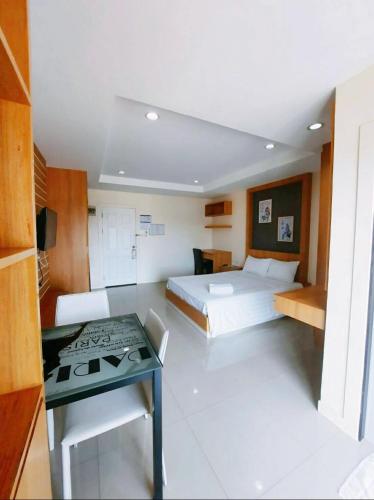a room with two beds and a table in it at Sea Hill Hotel Bangsaray in Bang Sare