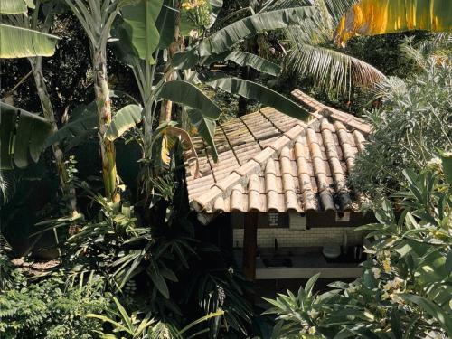 a house in the middle of a forest of trees at Carambola Hotel in Arraial d'Ajuda