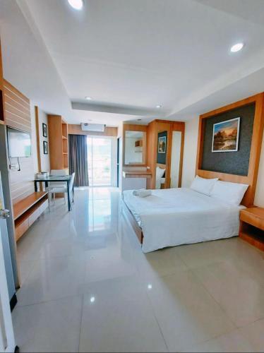a bedroom with a large white bed and a desk at Sea Hill Hotel Bangsaray in Bang Sare