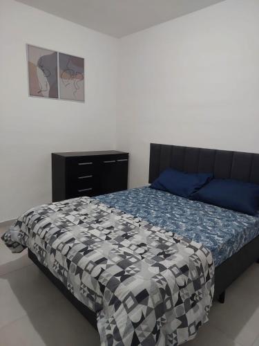 ein Schlafzimmer mit einem Bett und einer Kommode in der Unterkunft Boracéia Appartamento garaje & funcionalidade in Bertioga