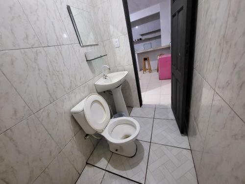 ein Badezimmer mit Toilette und Waschbecken in der Unterkunft Residencial Romulo Casa in Manaus