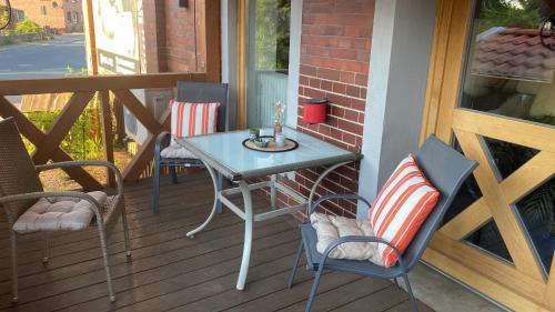 a table and chairs on a porch with a table at Ferienwohnung Schützenholz Einraumwohnung- Zwei Betten in Clenze
