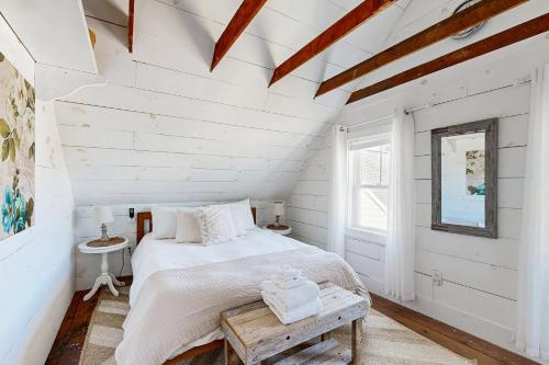 a white bedroom with a bed and a window at Bayside Gardens Grande in Boothbay Harbor