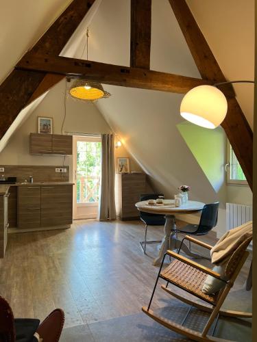 une cuisine avec une table et des chaises dans une pièce dans l'établissement Le Loft by Le Petit Pressoir, à Saint-Gatien-des-Bois