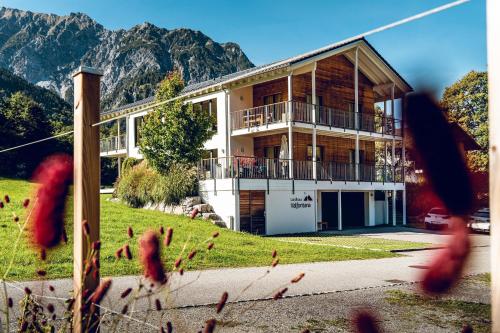a house on a hill with mountains in the background at Landhaus Valfontana in Vandans
