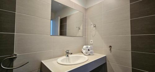 ein Badezimmer mit Waschbecken und Spiegel in der Unterkunft Studio Dolce & Vita C2 vue mer avec piscine in Propriano