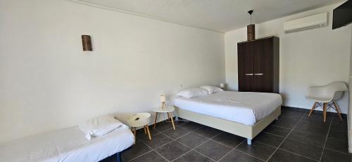 ein Schlafzimmer mit 2 Betten und einem Stuhl darin in der Unterkunft Studio Dolce & Vita C2 vue mer avec piscine in Propriano