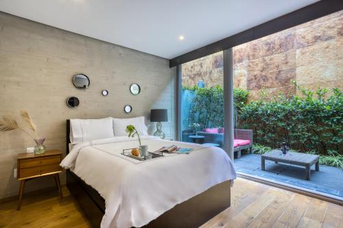 een slaapkamer met een groot bed en een groot raam bij AR 218 Hotel by ULIV in Mexico-Stad