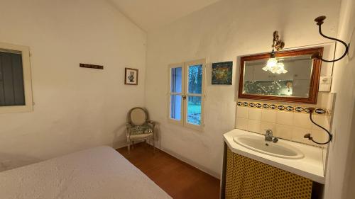 une salle de bain avec un lavabo, un lit et un miroir dans l'établissement Ateliers créatifs, à Puyvert