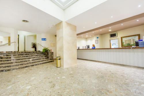 a lobby of a building with a staircase and aasteryasteryasteryasteryasteryastery at Hotel Tres Anclas in Gandía