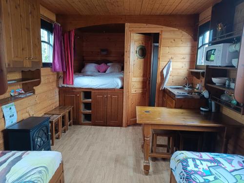 Cette petite chambre comprend un lit dans une cabine. dans l'établissement La roulotte la tribu deschpouss, à Saint-Christophe-en-Boucherie