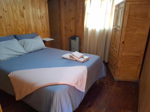 a bedroom with a bed with two towels on it at Cabañas Santa Flavia in Yacimientos de Río Turbio