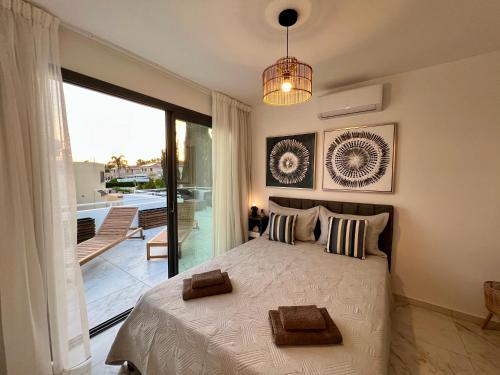 a bedroom with a large bed and a balcony at FatCow Beach Apartment Ultra in Larnaca