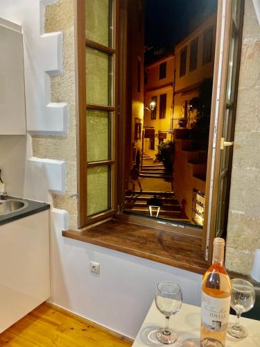 a window in a kitchen with two wine glasses on a counter at Erietta Suites in Chania