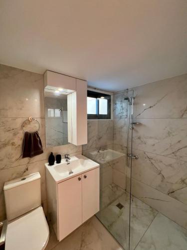 a bathroom with a toilet and a shower and a sink at FatCow Beach Apartment Ultra in Larnaca