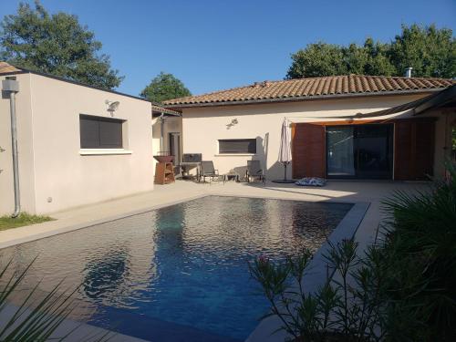 une piscine devant une maison dans l'établissement Gîtes Boisé en Cévennes - Ô Jardin d'À Côté, à Avèze