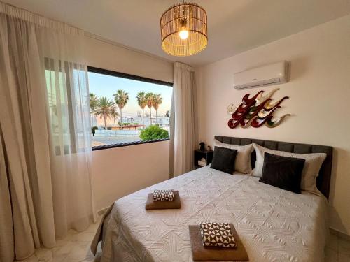 a bedroom with a bed and a large window at FatCow Beach Apartment Ultra in Larnaka