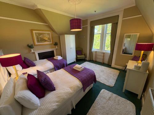 Un dormitorio con dos camas con almohadas moradas. en Rhumhor House, en Carrick