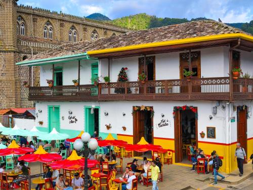 a building with tables and umbrellas in front of it at Apartamento nuevo en primer piso in Jardin