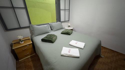 a bedroom with a bed with towels on it at Casas de Temporadas - Hotel Recanto do Sossego in Uberlândia
