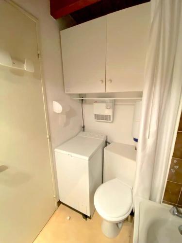 - une petite salle de bains blanche avec toilettes et lavabo dans l'établissement Joli duplex en centre station, au Sauze