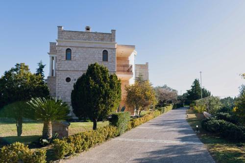 a building with a road in front of it at Seaside "Stone & Light Villa" close to Aegina City in Khlóï