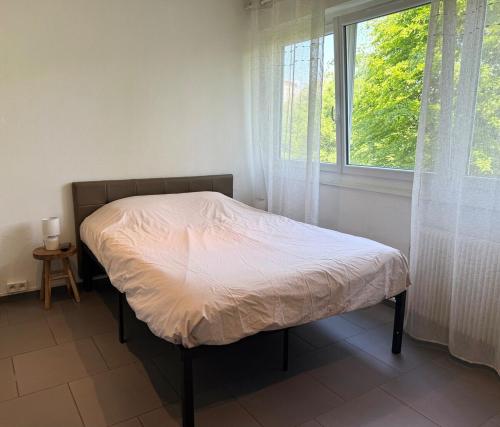 un lit dans une chambre avec une fenêtre dans l'établissement Studio tout confort cité de la gastronomie (3), à Dijon