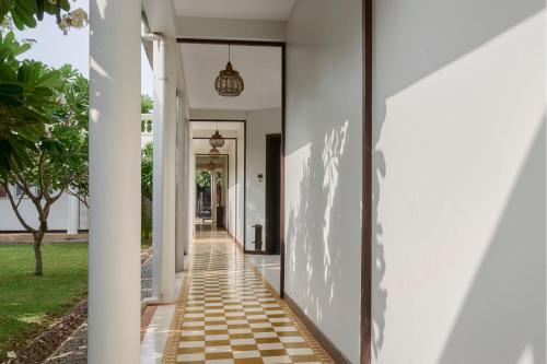 a hallway of a house with white walls at The Embassy Angkor Resort & Spa in Siem Reap