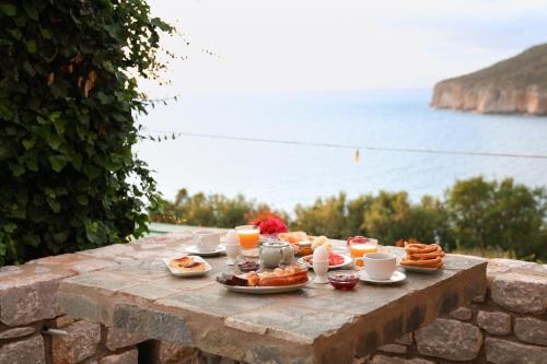 a table with breakfast foods and drinks on top of a wall at Panorama Rooms in Pirgos Dhirou