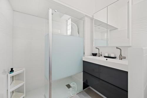 une salle de bain blanche avec un lavabo et une douche dans l'établissement T3 L'escapade Mont des oiseaux Piscine Clim Parking By HC, à Hyères