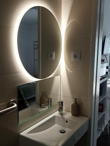 a bathroom with a sink and a mirror at Beach Avenue Suite in Apúlia