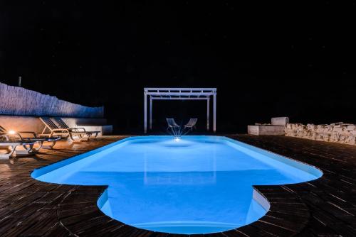 a large blue swimming pool in a dark room at Monte Do Malhao - Art, Eco & Spa in Castro Marim