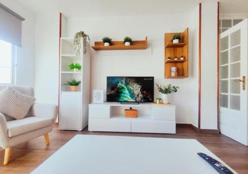 a living room with a tv on a white cabinet at Escapada Deluxe con Wifi 2 Hab 2 Baños con Cocina & SmartTV cerca de Todo in Santa Cruz de Tenerife