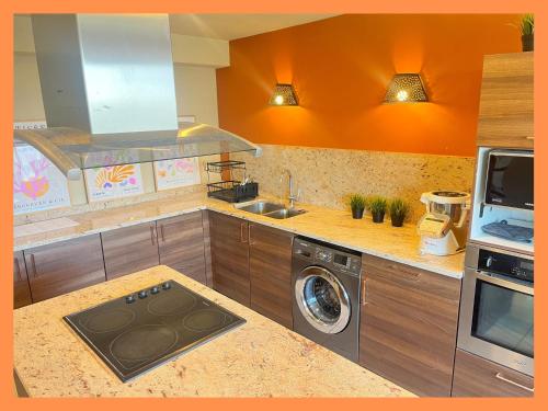 a kitchen with a sink and a washing machine at Les suites de la Villa Morane in Perpignan