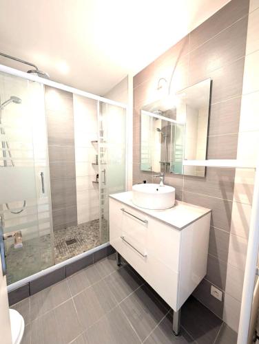 une salle de bain blanche avec un lavabo et une douche dans l'établissement 2 Pièces agréable, Proche Centre-ville, à Lorient