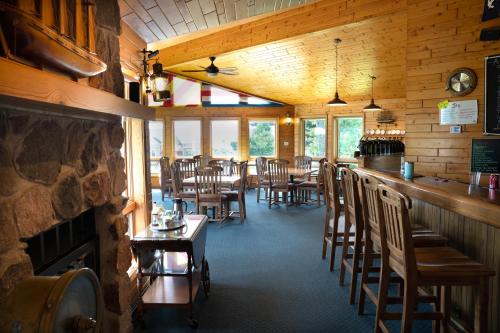 un comedor con bar, mesas y sillas en Square Rigger Lodge, en Jacksonport