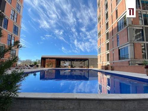 a large swimming pool in the middle of a building at Departamento residencial con alberca y gym in Guadalajara