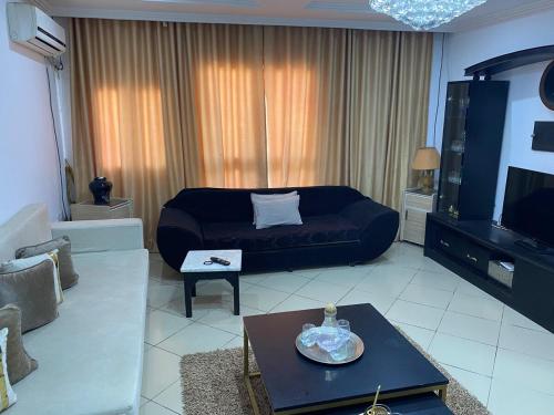 a living room with a couch and a tv at Maison Chkili in Bin Rhilouf