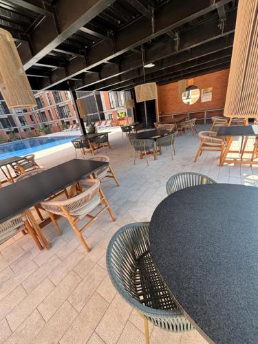 a patio with a table and chairs and a pool at Departamento residencial con alberca y gym in Guadalajara