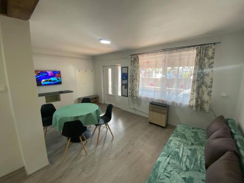 a living room with a green table and a couch at Pompa Apartman in Nyíregyháza