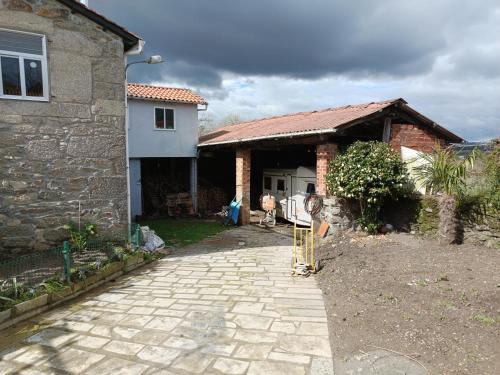 a house with a stone walkway in front of it at Casa Nodar in Chantada