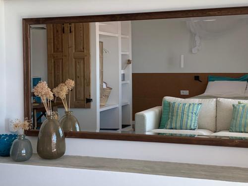 a mirror reflecting a living room with a couch at Casa no Rio - River House in Vila Nova de Milfontes