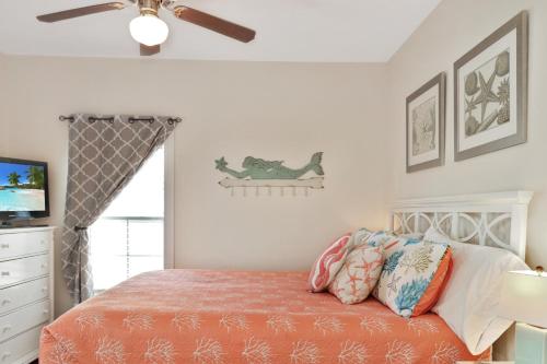 Un dormitorio con una cama y un ventilador de techo. en Barefoot Cottage B12 - Sea La Vie by Pristine Property Vacation Rentals, en Highland View