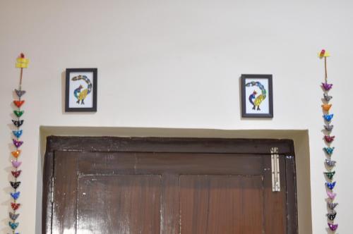 a door in a room with three pictures on the wall at Shardas Homestay in Ajmer