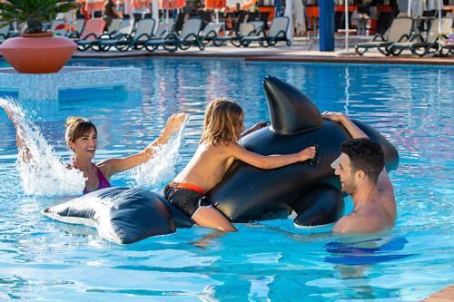 a group of people riding on a dolphin in a pool at Bibione Palace Hotel in Bibione